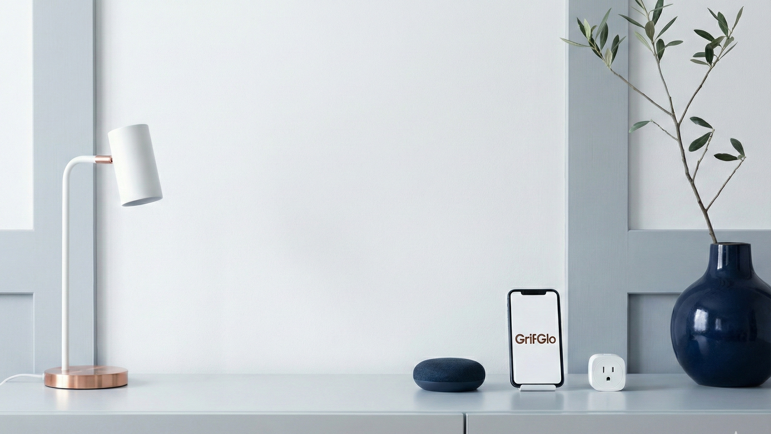Smart home devices on a white surface with a lamp and vase in the background